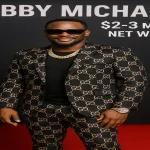 ubby Michael wearing designer outfit at red carpet event showcasing his $2-3 million net worth
